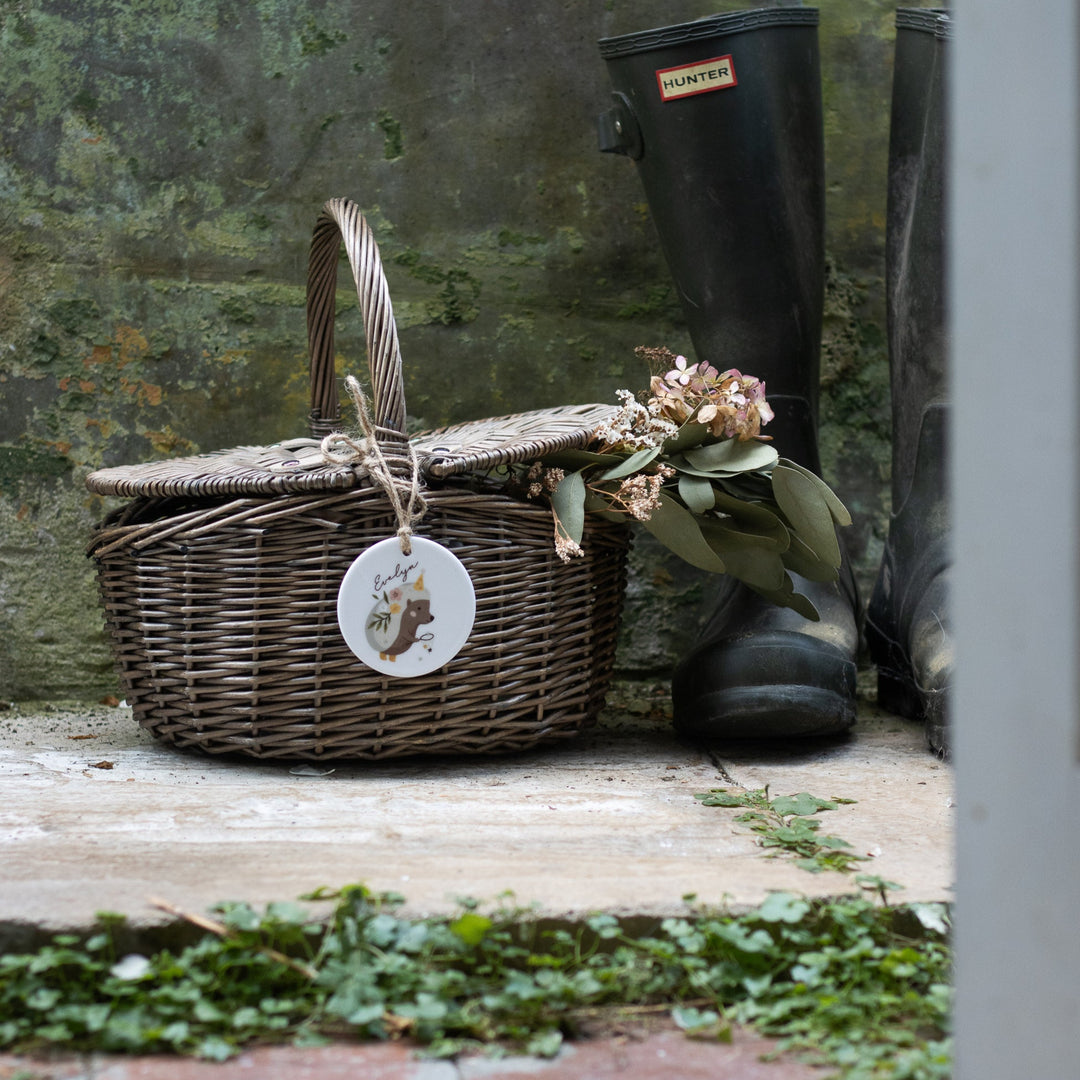 Wicker picnic basket with personalised ceramic tag featuring a hedgehog illustration